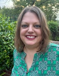 Katie Cruice Smith, smiling outdoors in a green blouse